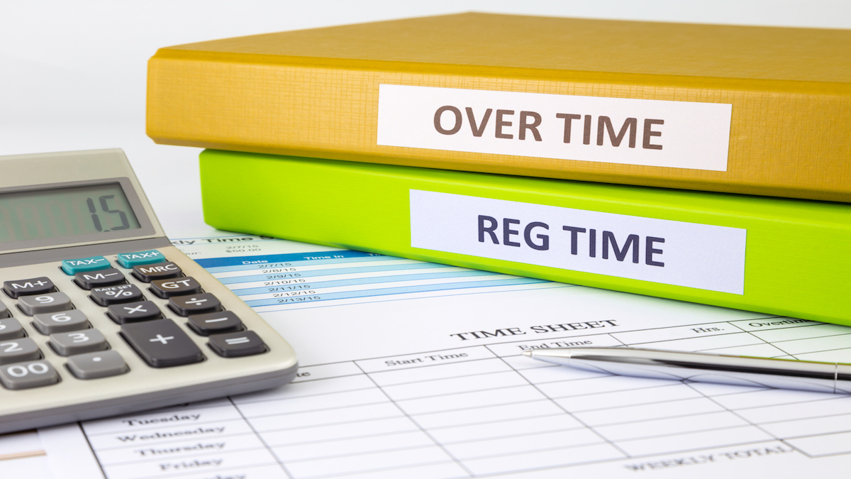 Regular time and Over time words on labels, document binders place on blank payroll time sheets