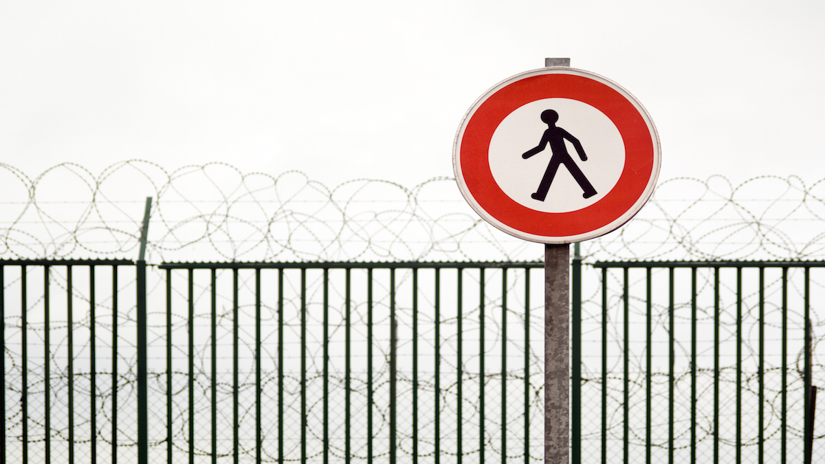 No Trespassing sign at a barbed wire fence.