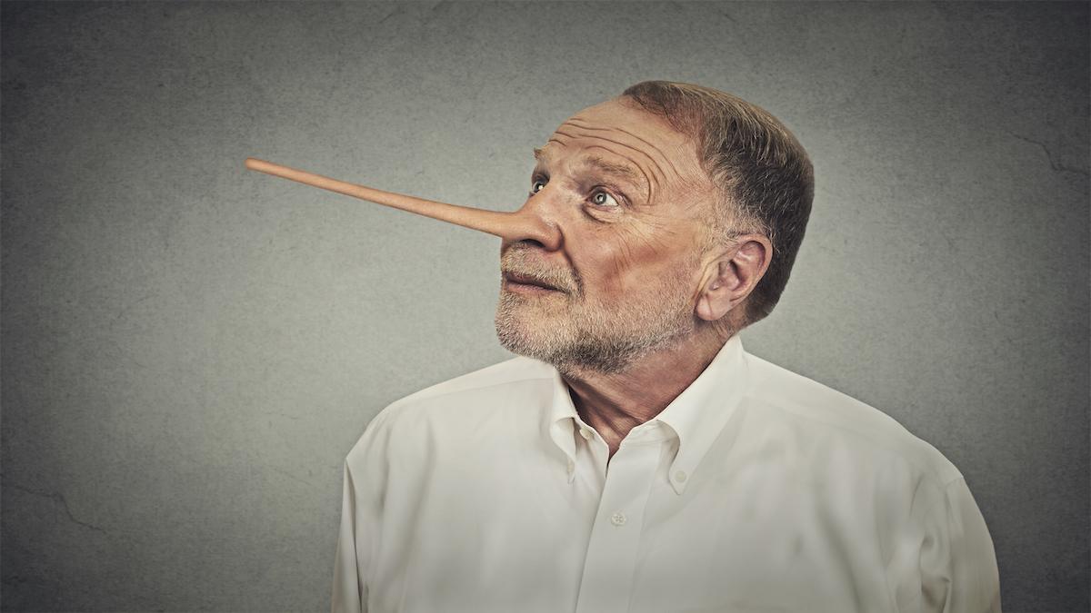 Man with long nose looking up avoiding eye contact isolated on grey wall background. Liar concept. Human face expressions, emotions, feelings.